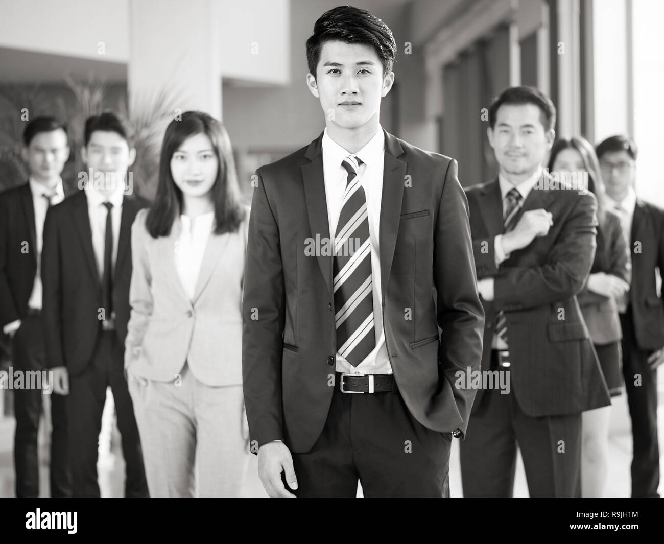 Porträt einer Mannschaft der Erfolgreichen asiatischen Unternehmer und Unternehmerinnen, von der Kamera suchen, Schwarz und Weiß. Stockfoto