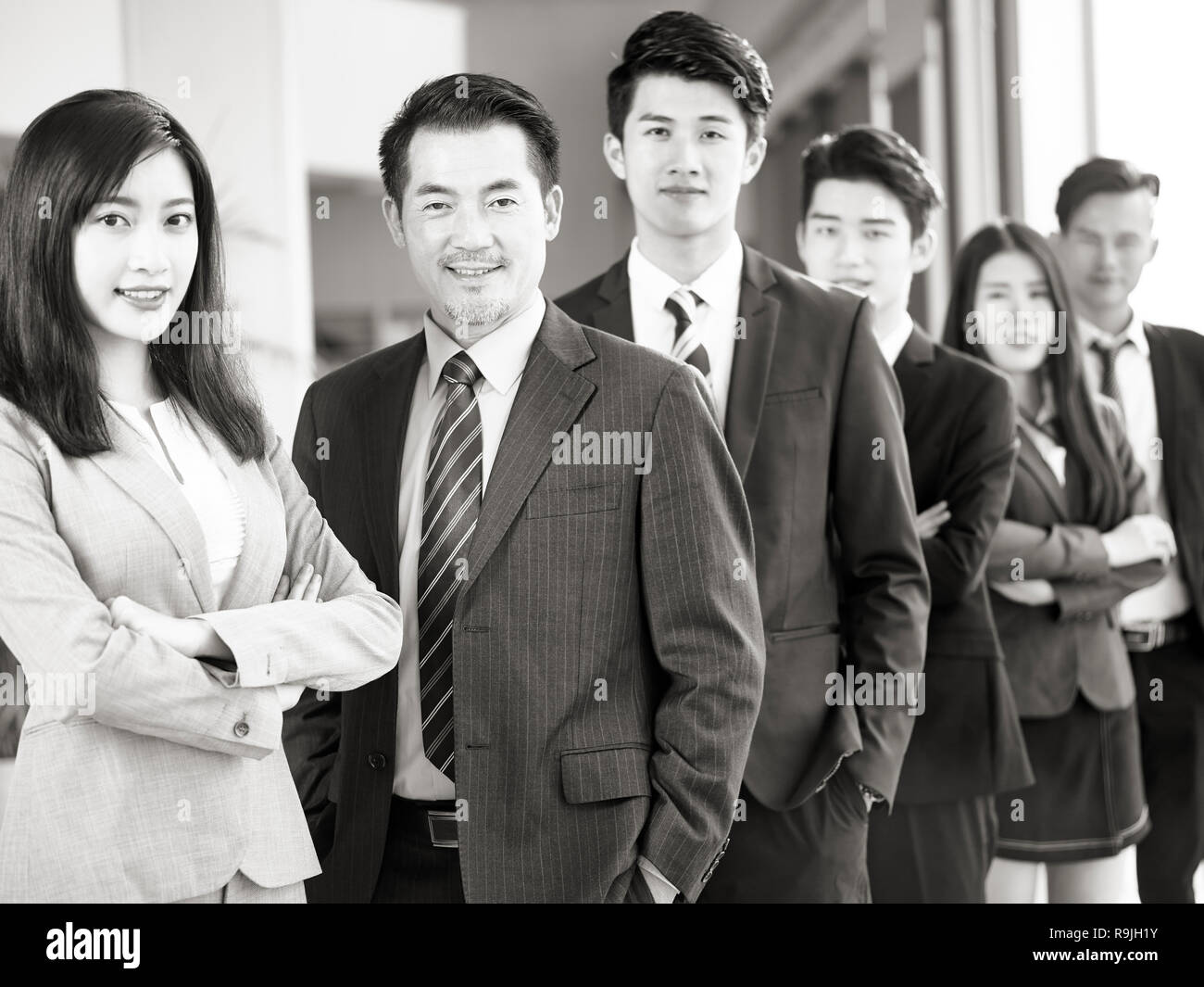 Porträt einer Mannschaft der Erfolgreichen asiatischen Unternehmer und Unternehmerinnen, in die Kamera lächeln suchen, Schwarz und Weiß. Stockfoto