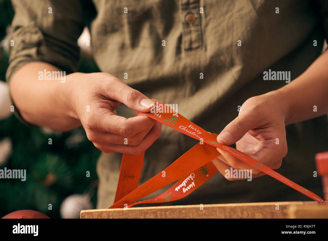 Die Vorbereitung auf die Weihnachtsferien. Männliche Hände Verpackung Geschenkbox Stockfoto