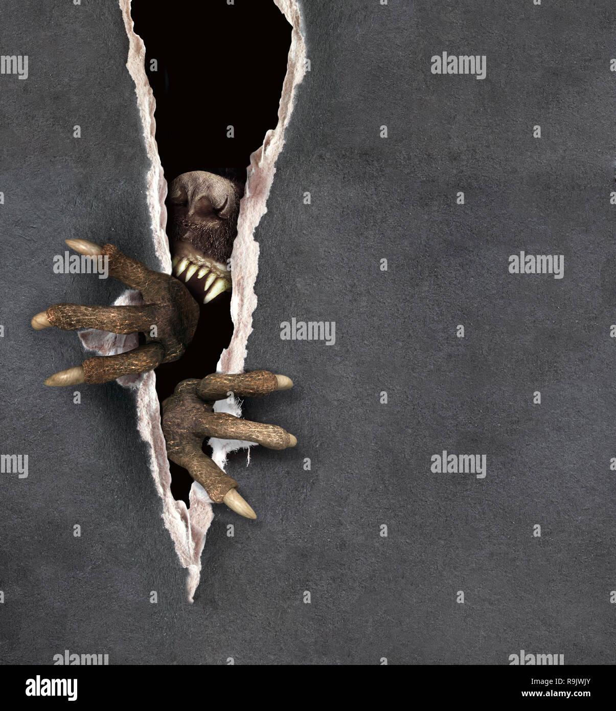 Dark-Serie - Pfoten eines Monsters reißt ein Papier Stockfoto