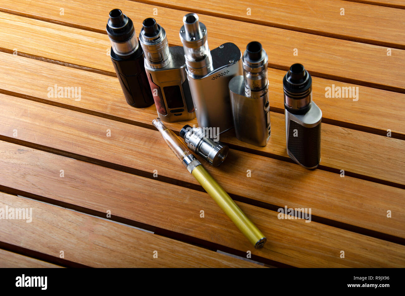 Beliebte vaping e cig Gerte mod. Elektronische Zigarette ber Holz-  Hintergrund. Vaporizer e-cig alten Gert Modell Stockfotografie - Alamy