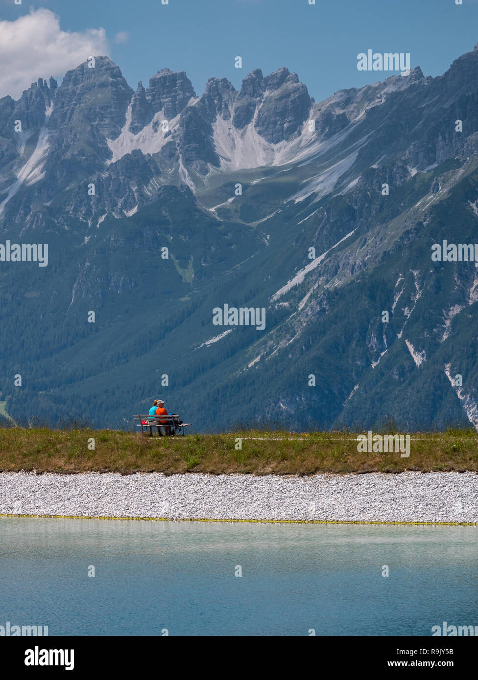 Ein paar der älteren Menschen ruht auf einer Bank in der Nähe der Bergstation der Seilbahn Serlesbahn Stockfoto