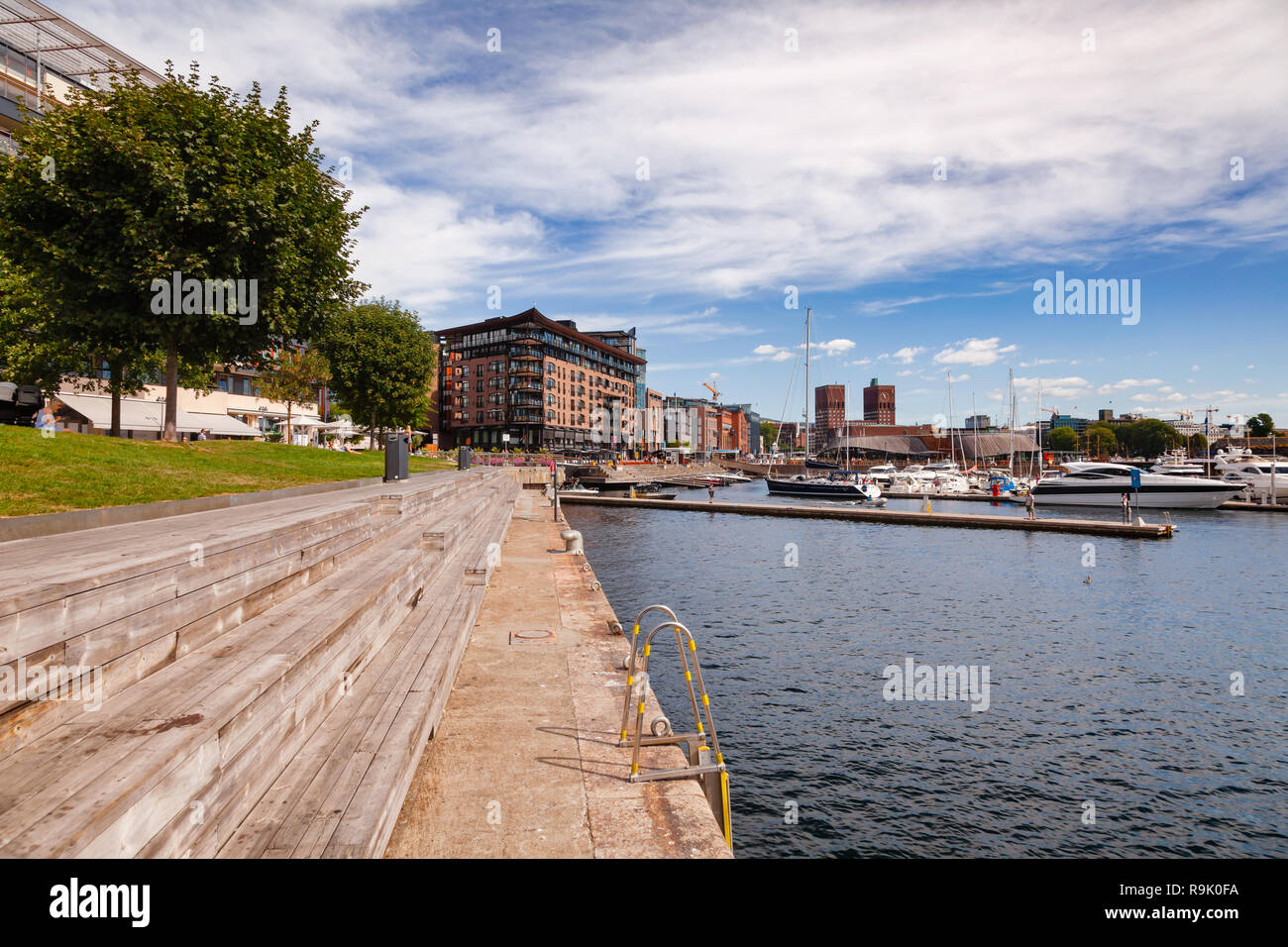 OSLO, Norwegen - 23. JULI 2018: Pier in renovierten Tjuvholmen Hafenviertel Aker Brygge Nachbarschaft und Marina ist im Hintergrund zu sehen Stockfoto