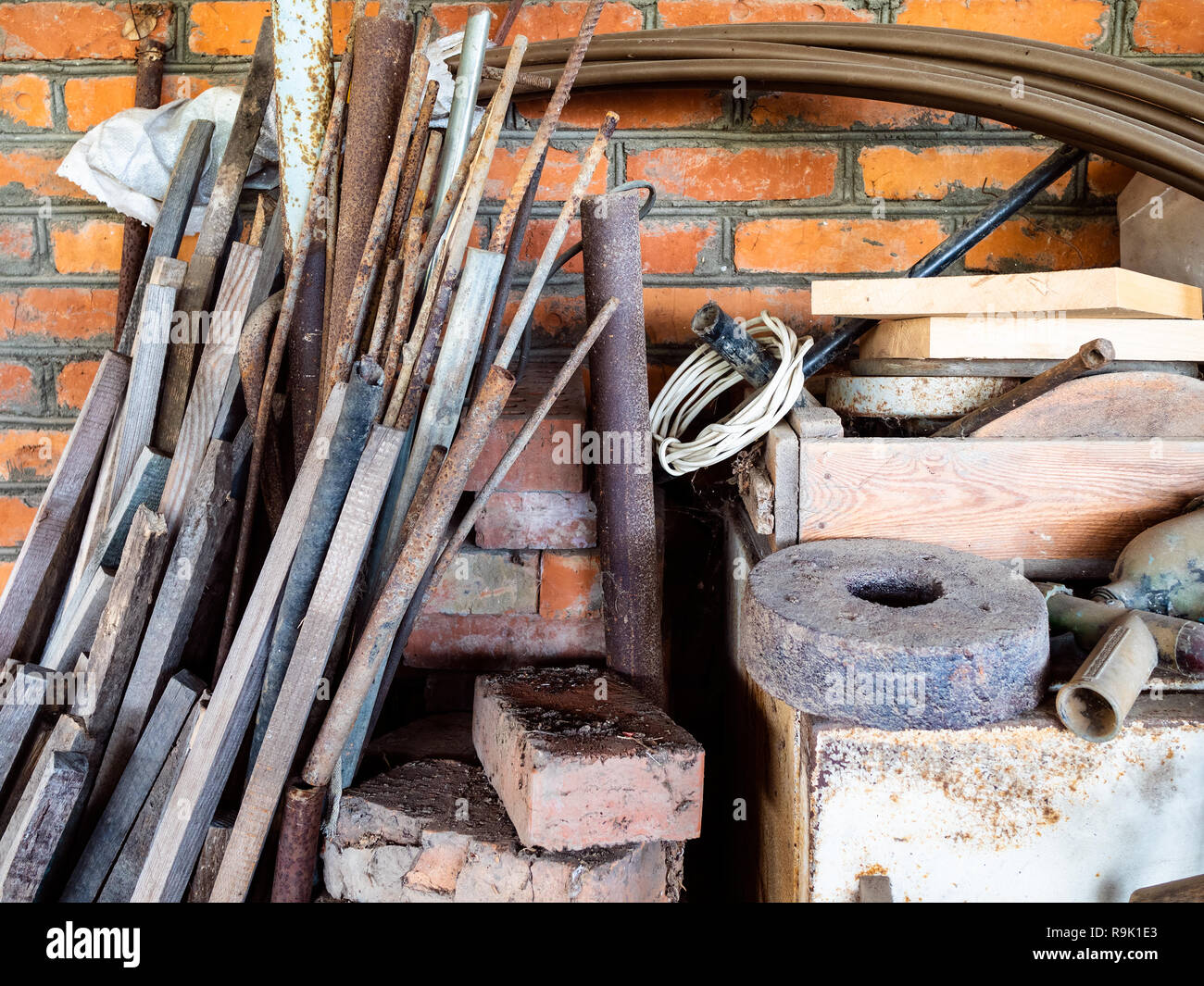 Alte Stöcke, Steine, Rohre und andere unnötige Tools in einem rustikalen Schuppen Stockfoto