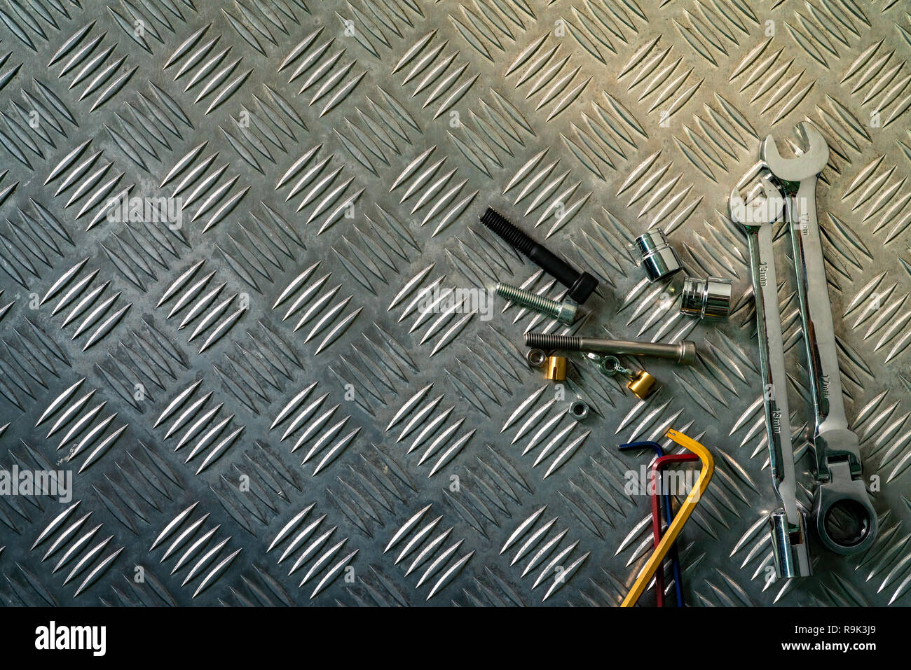 Blick von oben auf die Tools auf Industrial Metal Riffelblech. Metall checkerplate für Rutschfeste. Mutter, Schrauben und Inbusschlüssel auf Blech. Silber bump groun Stockfoto