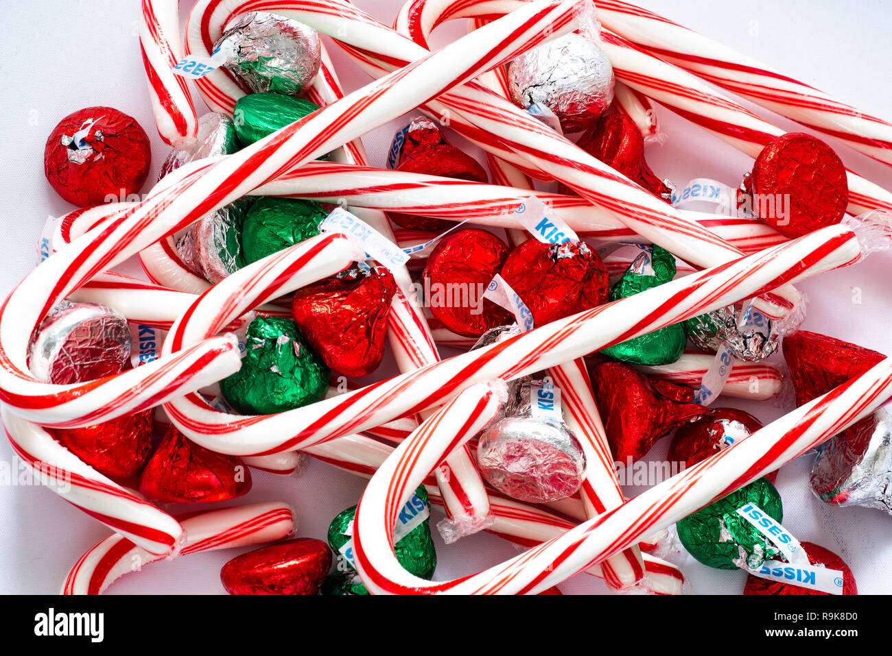 Ein Haufen pf rot-weißen Zuckerstangen und bunten Hershey Kisses für die Weihnachtszeit. Stockfoto