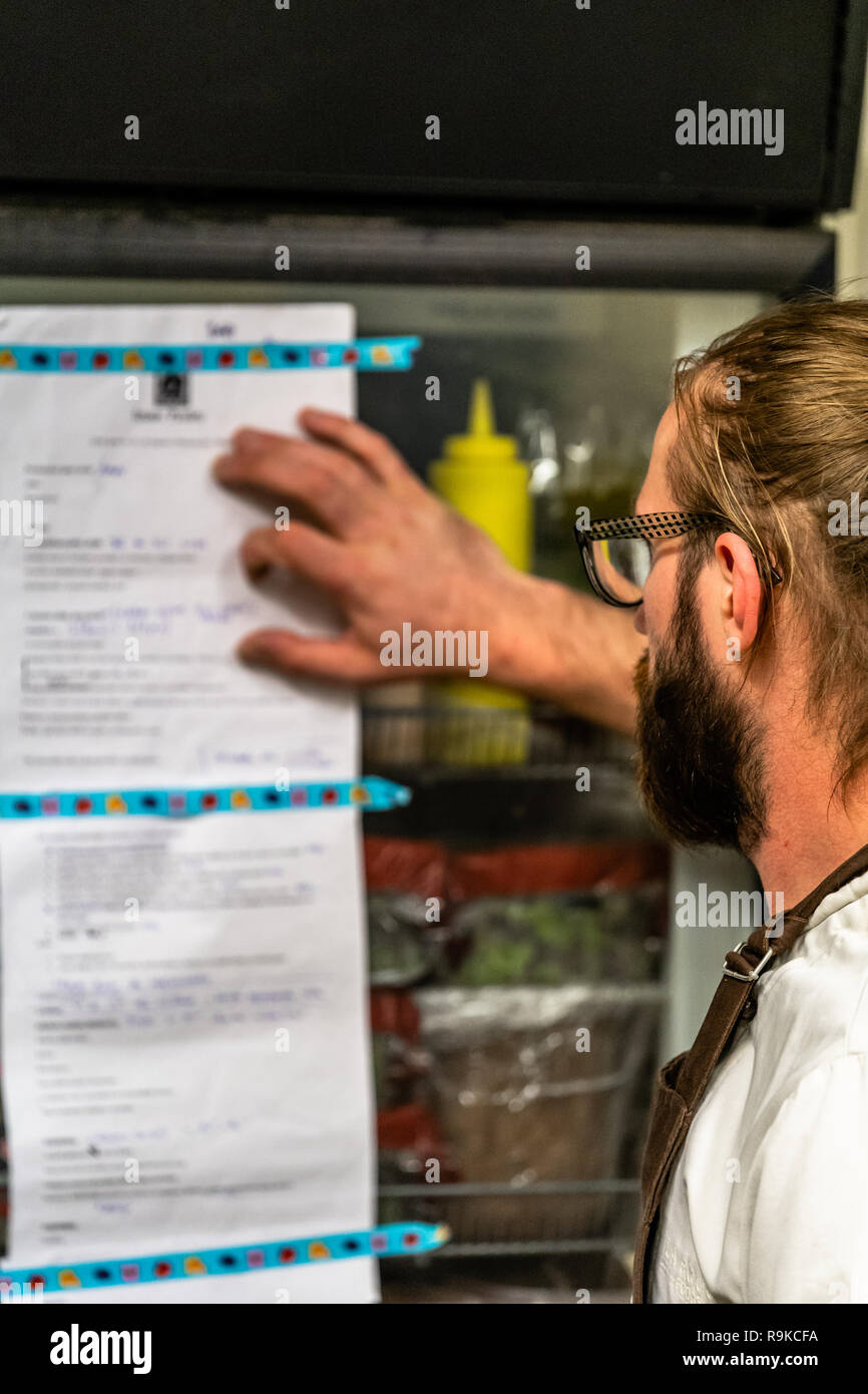 Männliche Koch das Kochen Liste am Kühlschrank - Küche Stockfoto