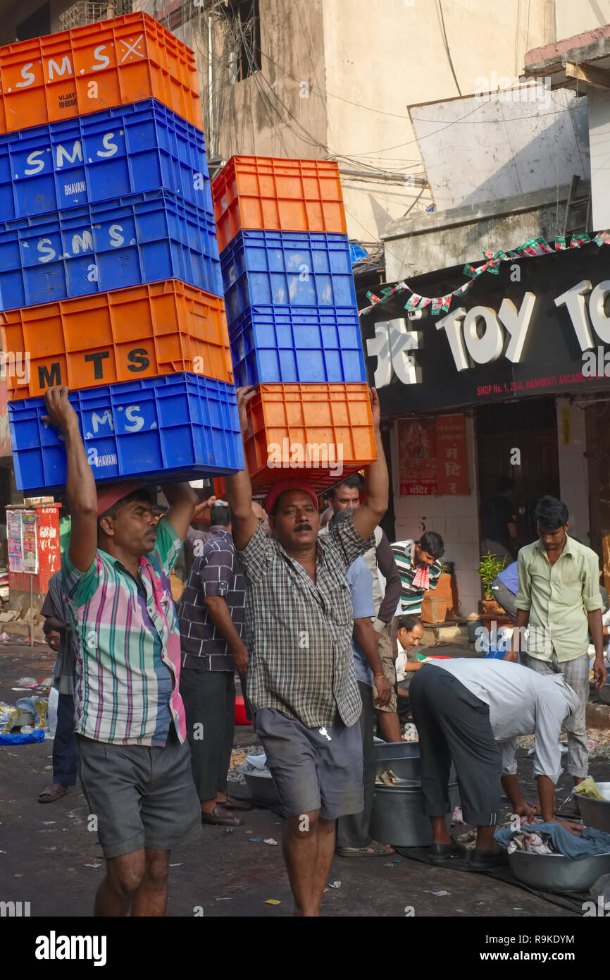 Torhüter balancing Kisten auf den Kopf in einen Fischmarkt in Mumbai, Indien Stockfoto