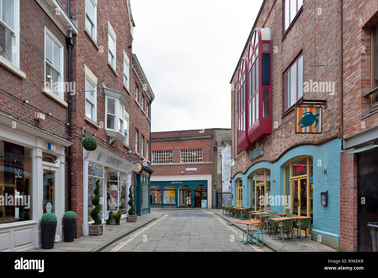 York, England - April 2018: die alten Ziegel Gebäuden, Geschäften und Restaurants auf der Gasse von wenig Stonegate im historischen Viertel der Stadt York, Engla Stockfoto
