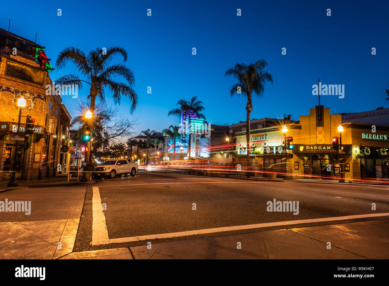 Schnittpunkt auf der Main Street in der Innenstadt von Ventura, Kalifornien, USA mit Weihnachtsbeleuchtung und Streifenbildung verkehr Scheinwerfer eingerichtet hat offenen Restaurants Stockfoto