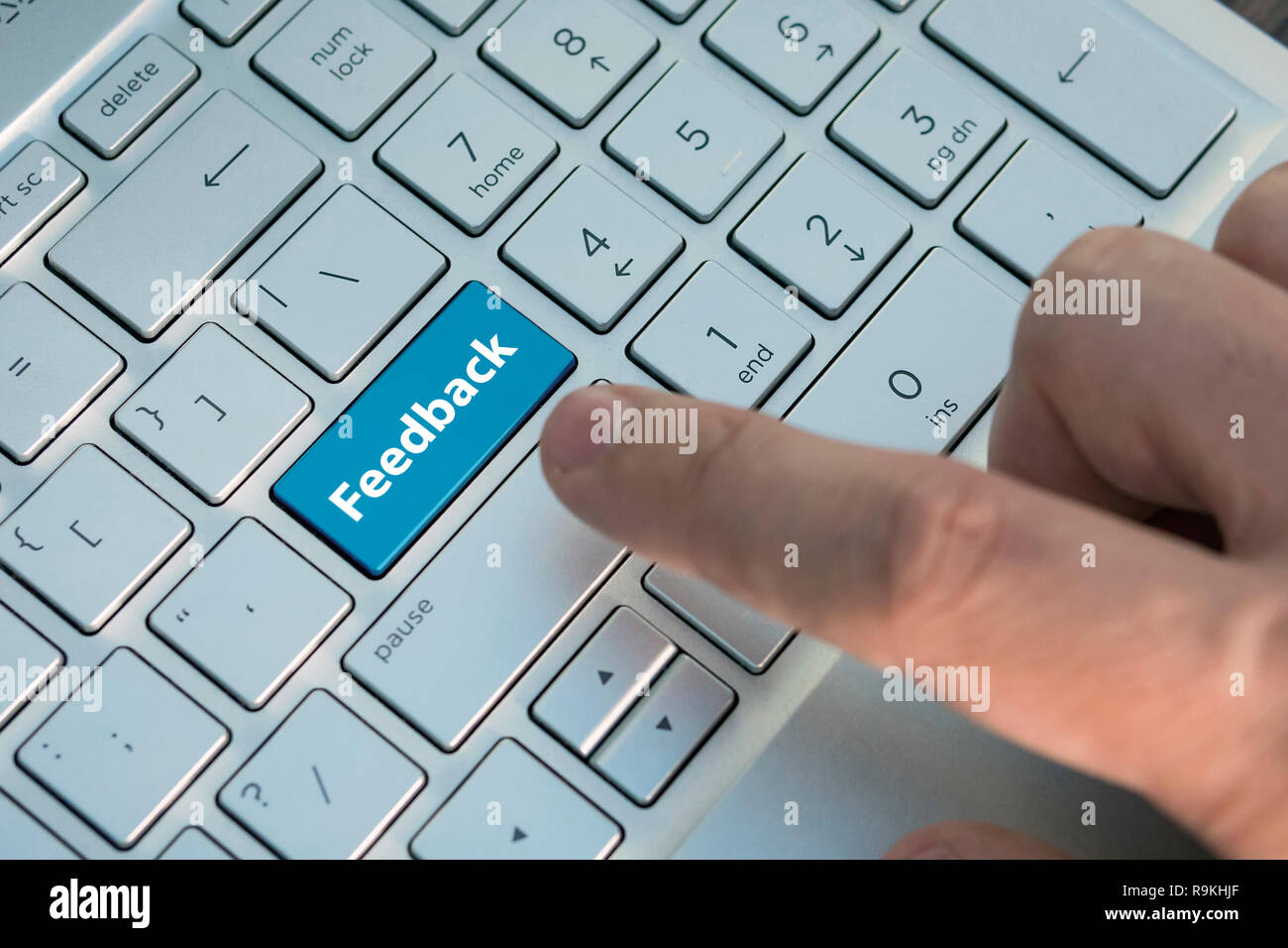 Computer Taste zeigt das Wort Feedback. Meldung auf der Tastatur drücken, einen männlichen Finger drückt eine Taste Farbe Grau Silber Tastatur eines modernen Laptop. Bu Stockfoto