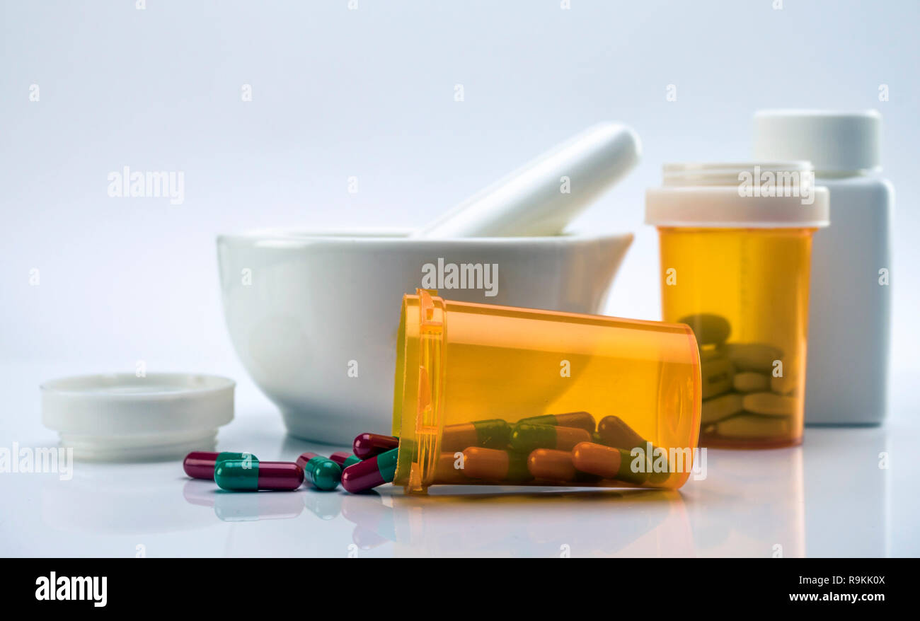 Mörtel pharmazeutische Neben mehreren Dosen von Kapseln auf weißem Hintergrund Stockfoto