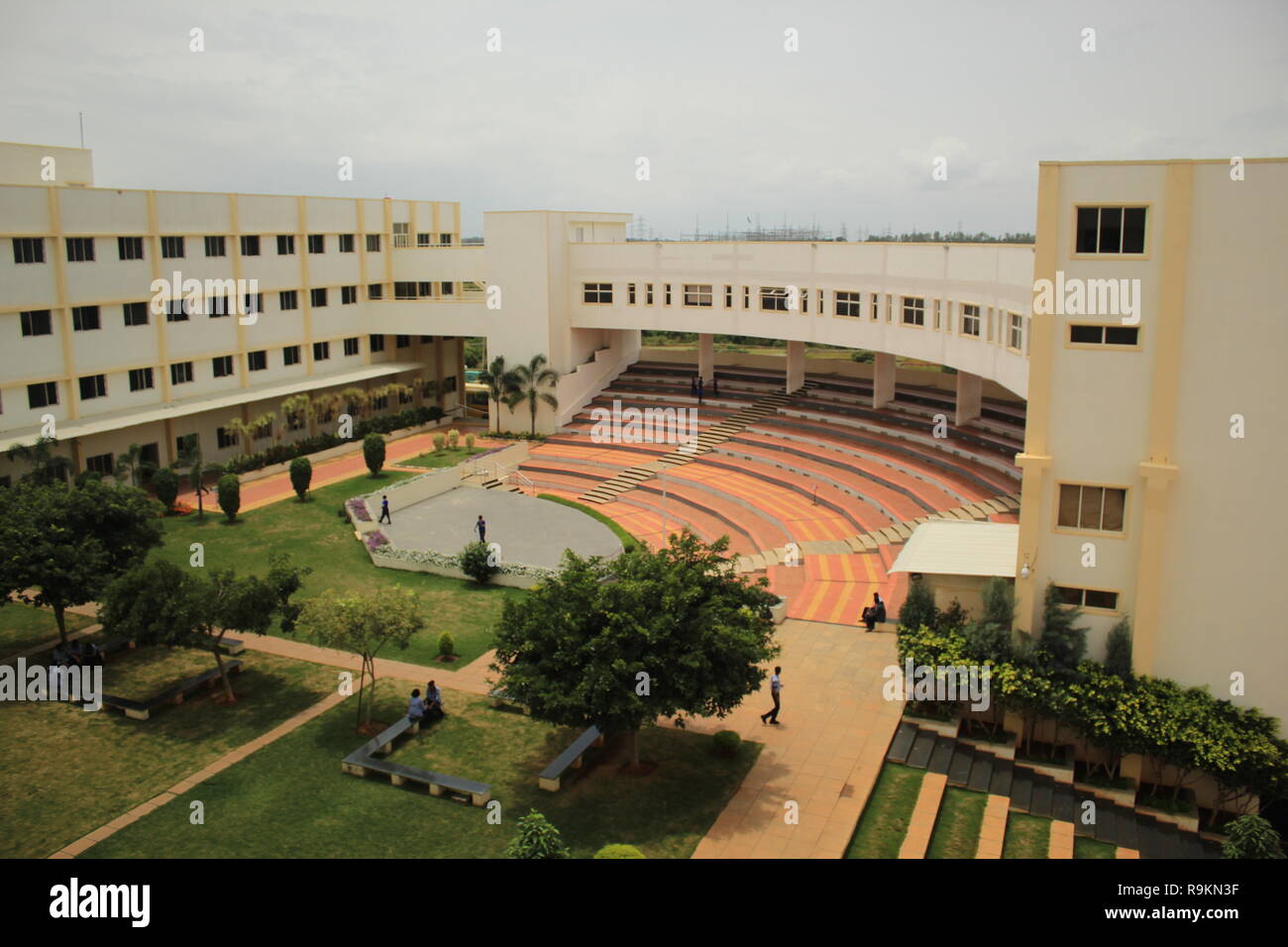 Ein Blick aus den oberen Stockwerken des Amphitheaters, Bühne, Garten, und Brücke von Excel öffentliche Schule, Mysore, Karnataka, Indien. Stockfoto