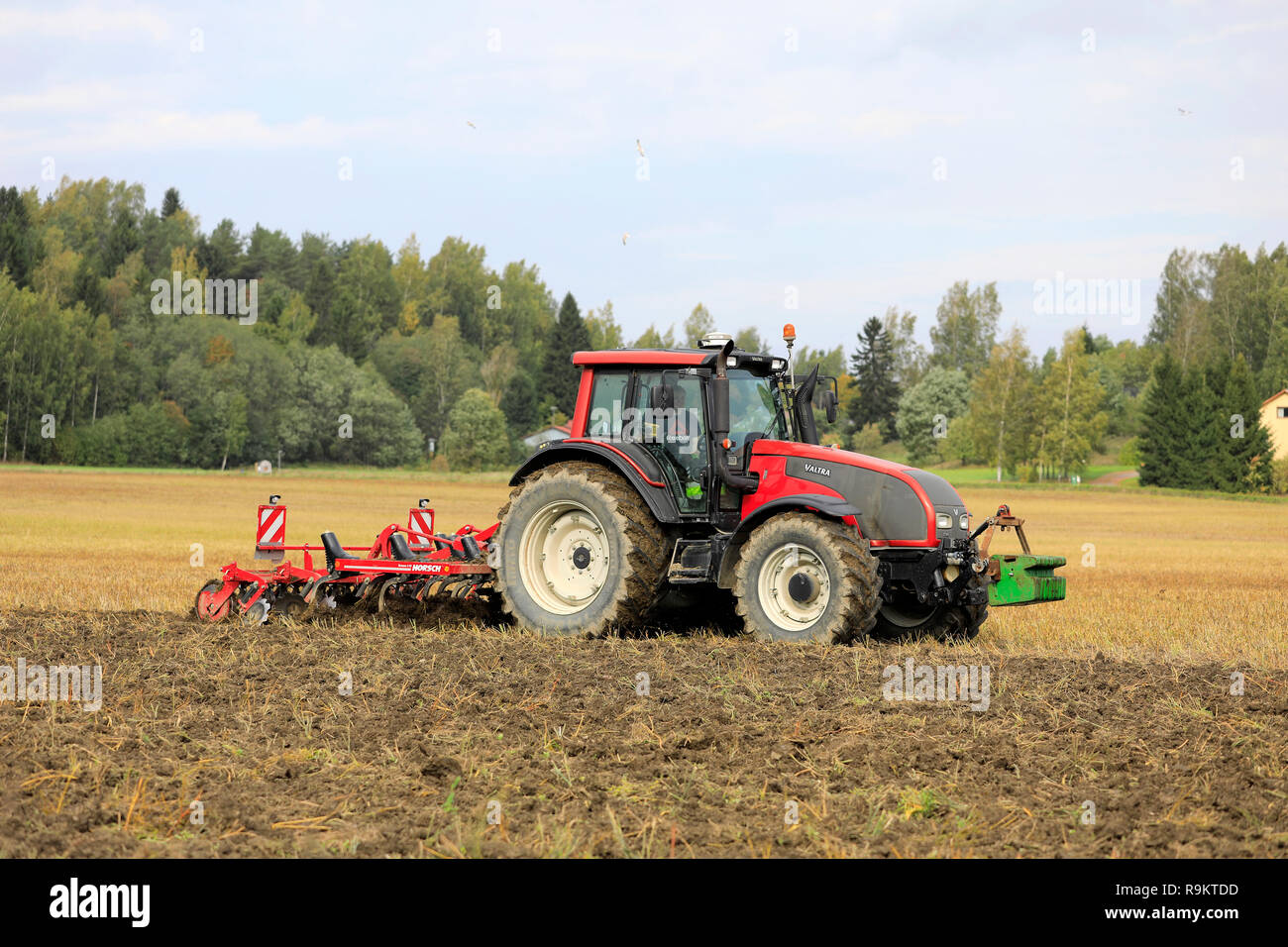 Salo, Finnland - 21 September, 2018: Landwirt pflegt geerntet Stoppeln Feld mit Valtra Traktor und Grubber Horsch Terrano 3 FX im Herbst. Stockfoto