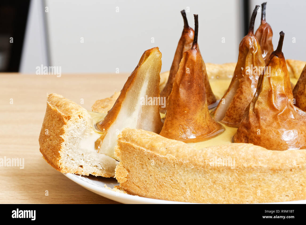 Torte mit Birnen, Sahne Butter und Marmelade auf weissem Holztisch. Ein Stück Kuchen. Stockfoto