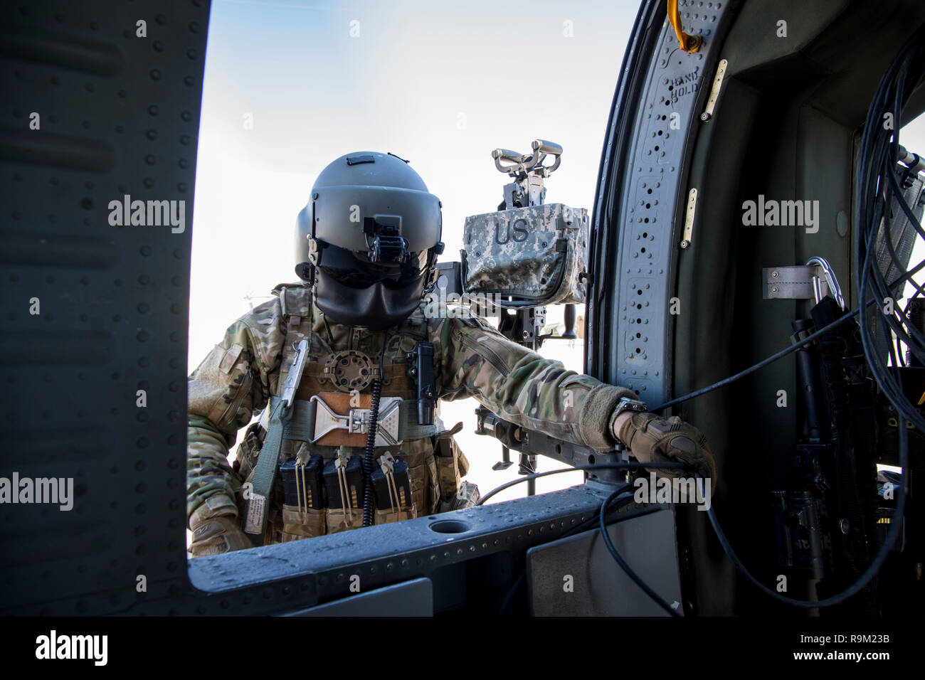 Die US-Armee Flight Engineer in der 738Th Air Expeditionary Beratenden Gruppe in einem afghanischen Luftwaffe UH-60 Blackhawk Dez. 5, 2018, während in den teilnehmenden NATO-led der entschlossenen Unterstützung der Mission in Afghanistan. Die Mission von Zug, beraten, unterstützen, Command-Air ist zu Trainieren, beraten, und die afghanischen Partner unterstützen eine Professionelle, leistungsfähige und nachhaltige Air Force zu entwickeln. TAAC-Air nutzt Zug, beraten und unterstützen Aktivitäten im Konzert mit starken persönlichen Beziehungen zu professionellen afghanischen Flieger in der Lage, Planung zu erstellen, zu führen, zu beschäftigen, und Aufrechterhaltung entscheidender Airpower. (U.s. Stockfoto