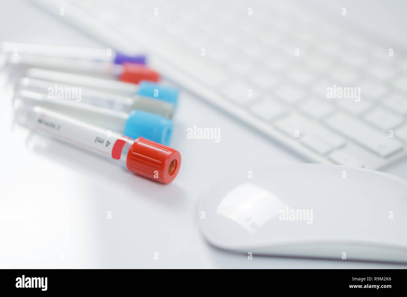 Medizin Flaschen für Proben neben Computer Tastatur und Maus in der Medizin, in der Nahaufnahme auf weißem Hintergrund Stockfoto