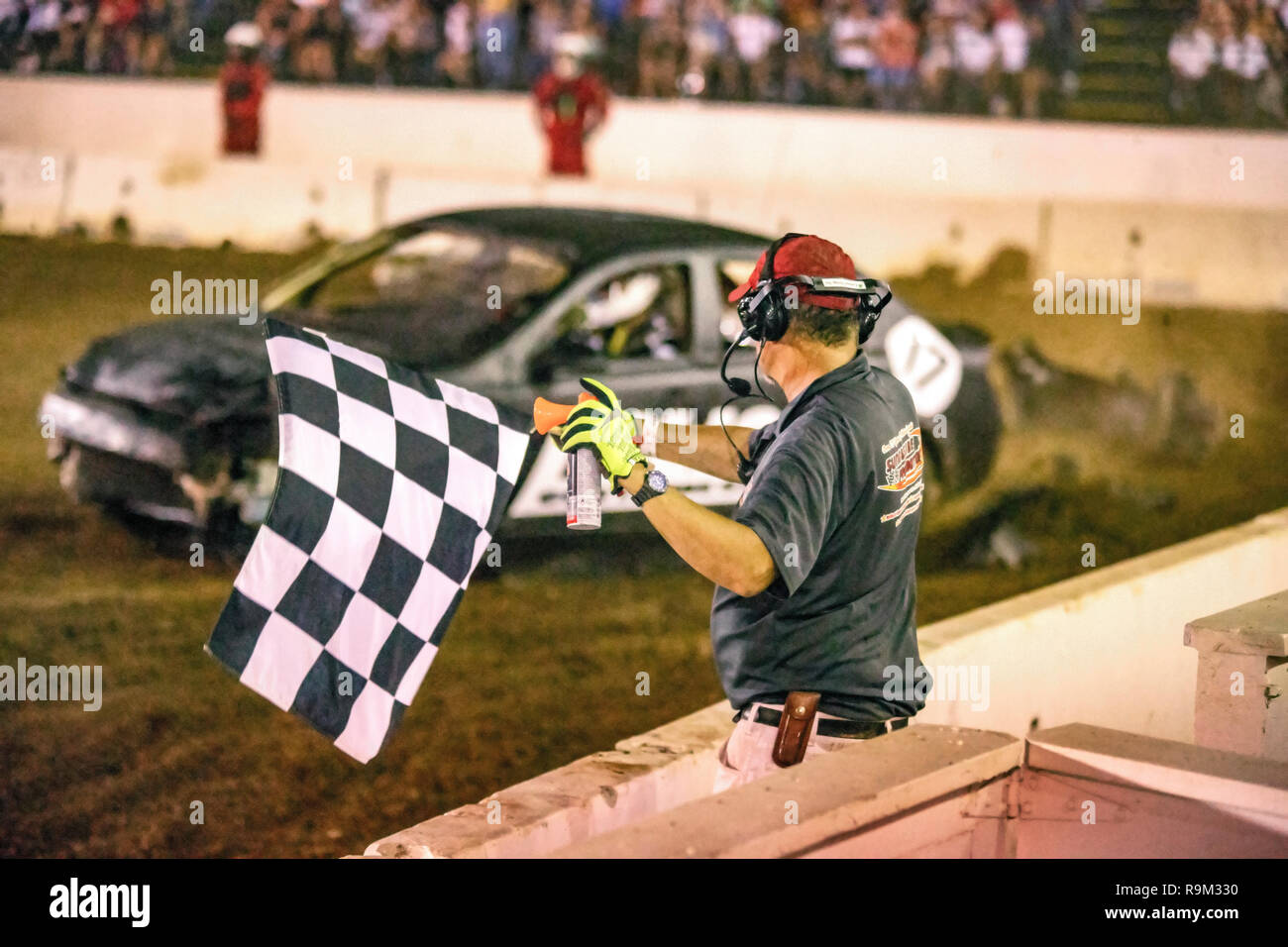 Ein Schiedsrichter Wellen eine Zielflagge den Abschluss eines Car-Absturz demo Derby in Costa Mesa, CA, Stadion zu signalisieren. Stockfoto