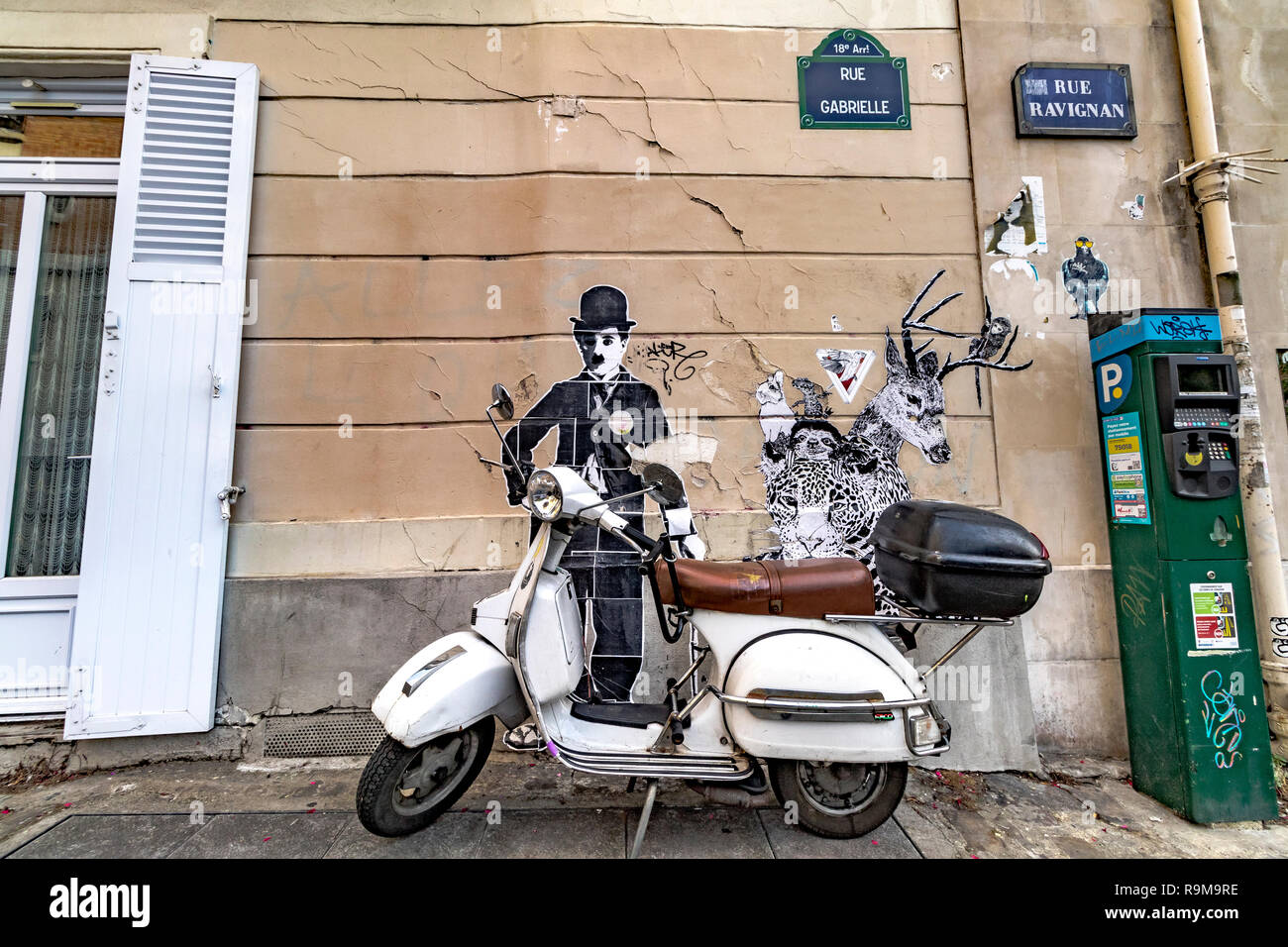Einen Roller vor einem Straße Malerei von Charlie Chaplin geparkt auf einem an der Wand eines Gebäudes in Montmartre, Paris Stockfoto