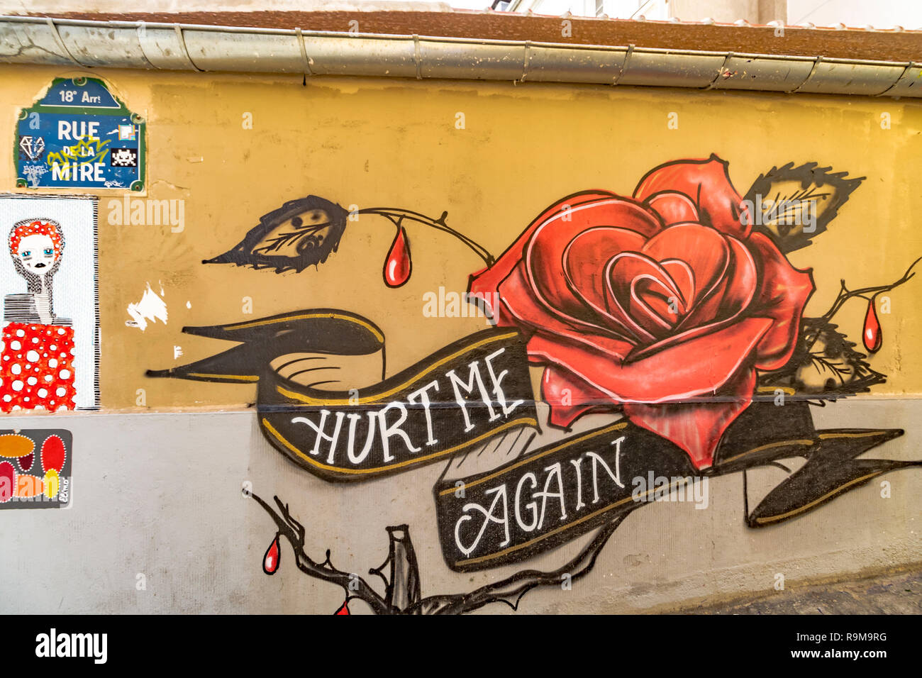 Eine gemalte rote Rose mit dem Slogan 'Hurt me again', gemalt auf einer Wand in Montmartre Paris, Frankreich Stockfoto