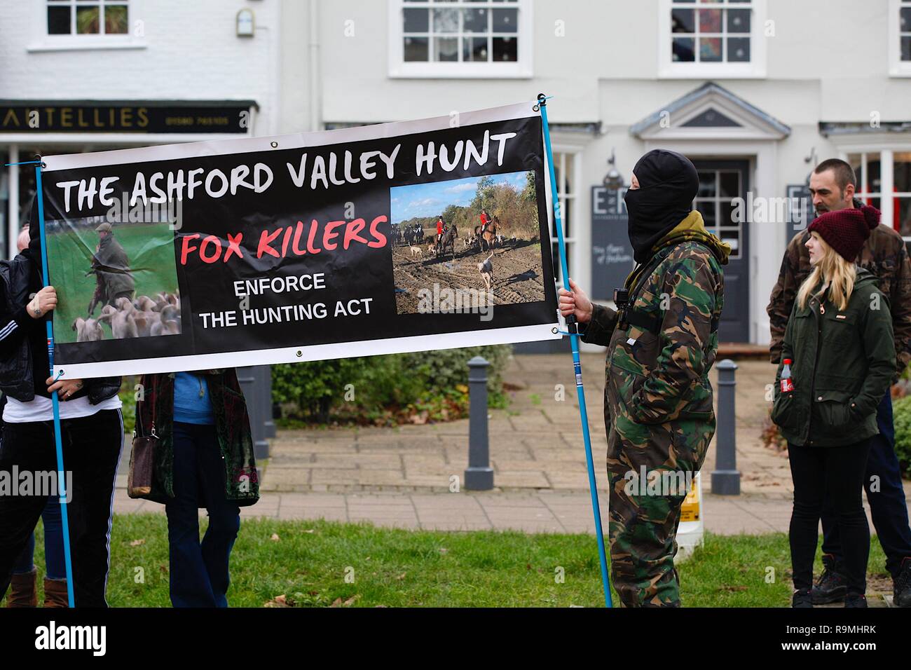 Tenterden, Kent, Großbritannien. 26 Dez, 2018. Die jährlichen Boxing Day treffen der Ashford Tal Tickham Jagd findet im Zentrum von Tenterden in Kent. Hunde und Pferde versammeln sich in der 'Vine Inn Pub bei 11, bevor Sie die High Street zu einem verpackten Publikum bin. Das Wetter ist mild und angenehm 8C für diese Zeit des Jahres. Tier rechte Demonstranten, die gegen die Jagd Die Jagd Compound. Credit: Paul Lawrenson/Alamy leben Nachrichten Stockfoto