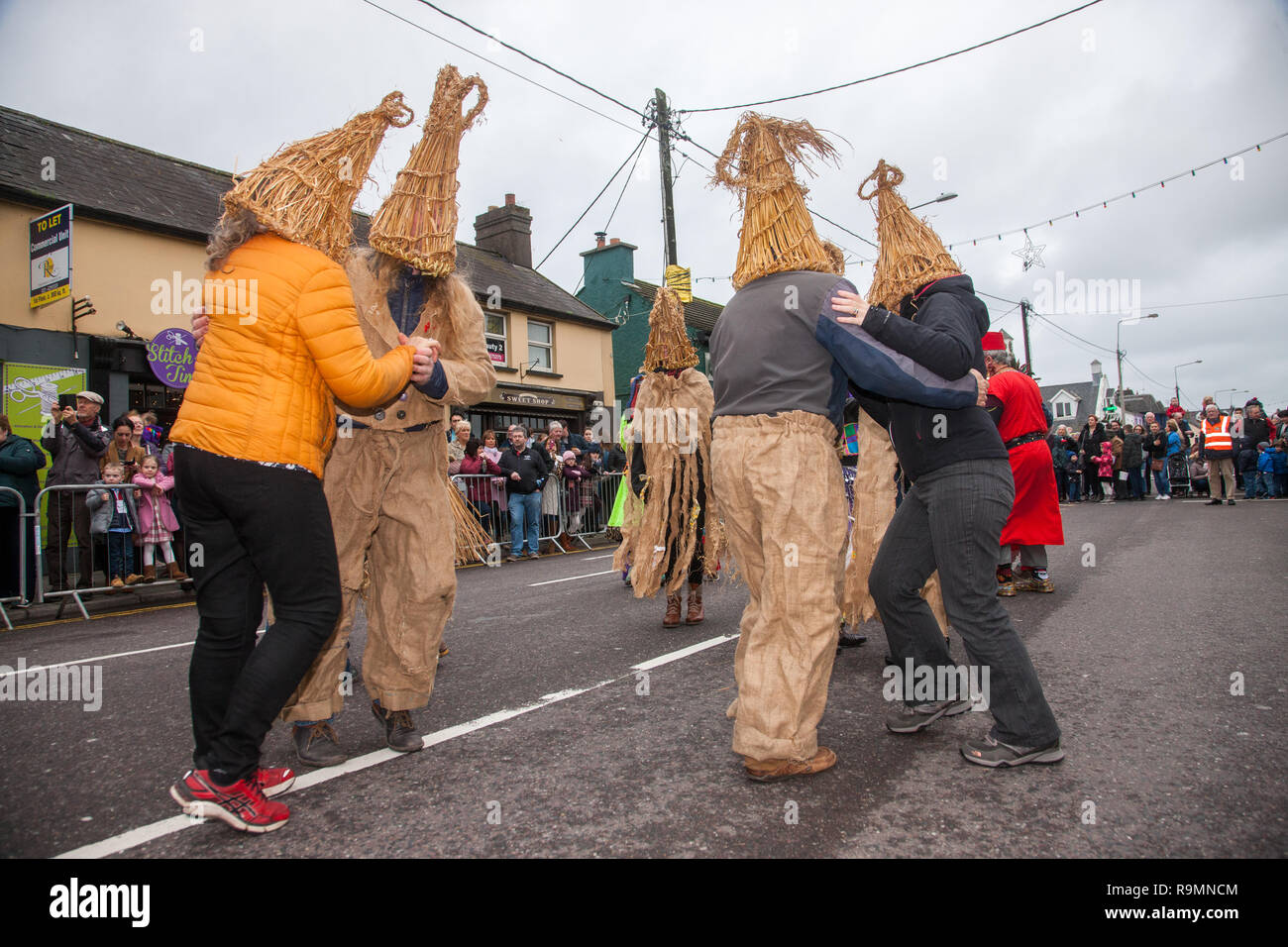 Carrigaline, Cork, Irland. 26. Dezember, 2018. Mitglieder der Carrigaline Comhaltas gekleidet wie Stroh Jungen tanzen ein sechzehn hand Haspel auf Hauptstraße als Teil der St. Stephen's Day Feiern im Carrigaline, Co Cork, Irland. Quelle: David Creedon/Alamy leben Nachrichten Stockfoto