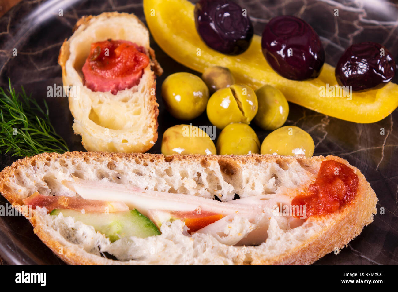 Nahaufnahme einer Sandwich. Sandwich mit Treffen, Prosciutto, Salami, Salat, Gemüse, Salat, Tomaten, Zwiebeln und Senf auf einer frischen in Scheiben geschnittenen Roggen Brea Stockfoto