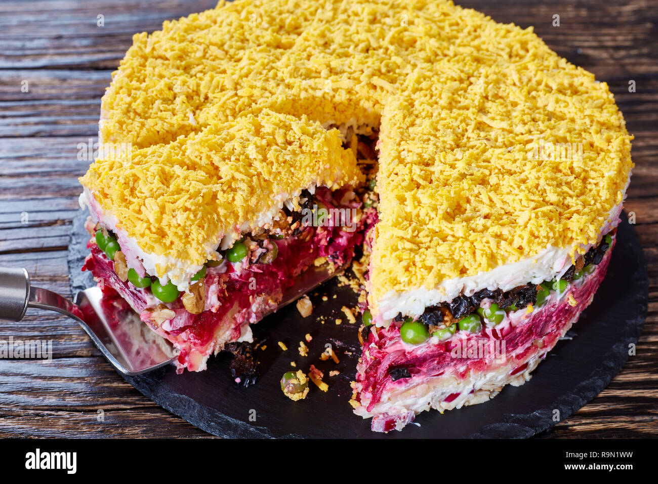 Köstliche sieben 2-in-1-Salat mit Gemüse, hart gekochte Eier, Pflaumen, Nüsse und Hähnchenfleisch auf schwarzem Schiefer Fach auf einem alten Holztisch. Blick von Stockfoto