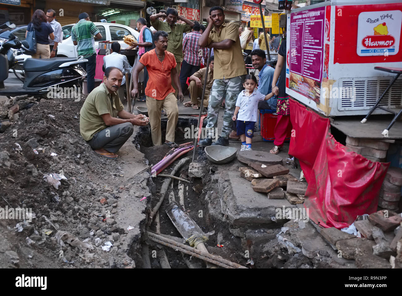 Gemeinde Mitarbeiter Festsetzung unterirdische Stromleitungen in einem überlasteten Gewerbegebiet in Mumbai, Indien, Hinzufügen zu dem allgemeinen Chaos Stockfoto