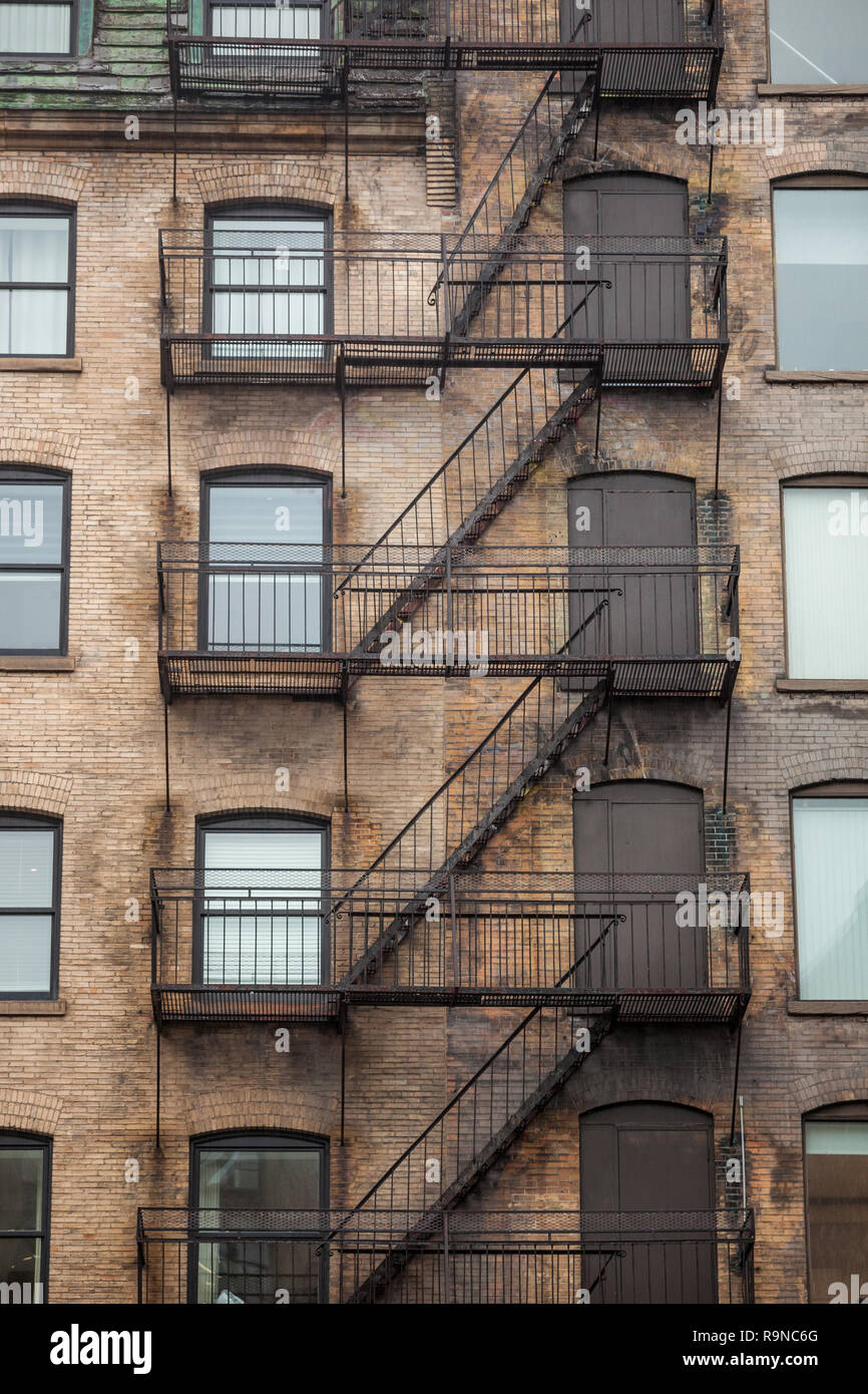 Notausgang Treppen und Leiter, aus Metall, auf einer typischen Nordamerikanischen alten Backsteingebäude aus dem alten Montreal, Quebec, Kanada. Diese Treppen, gemacht wurden. Stockfoto