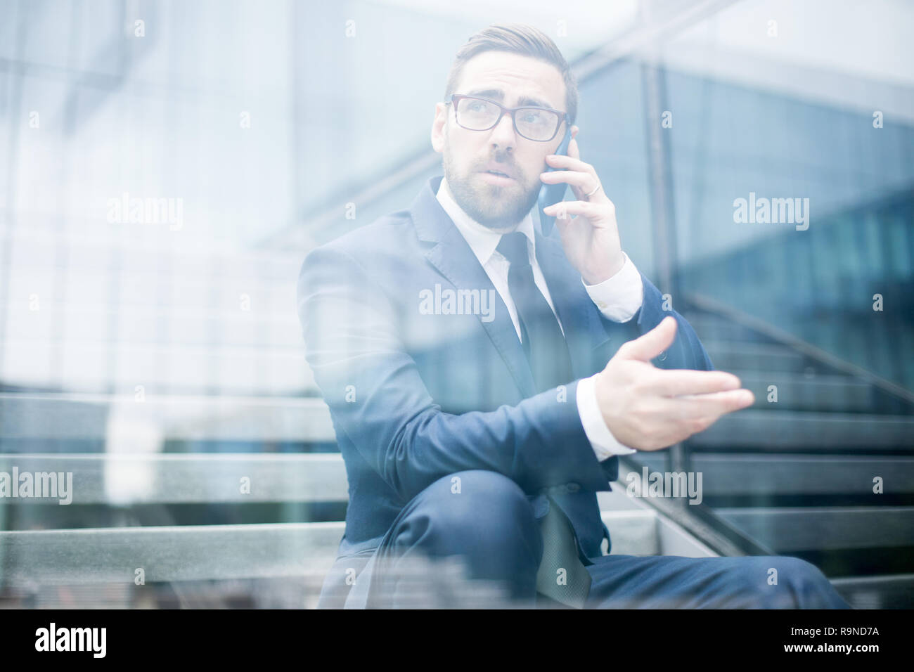 Business Mann sitzt auf Schritte reden Smartphone Stockfoto