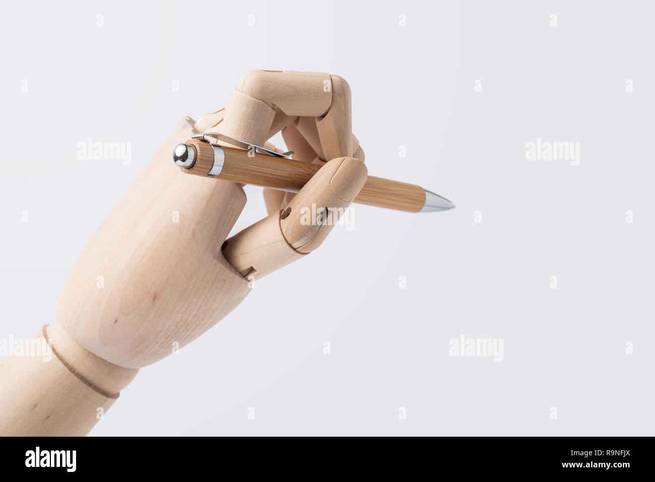 Business- und Designkonzept - hölzerne Hand halten Stift auf weißem Hintergrund Stockfoto