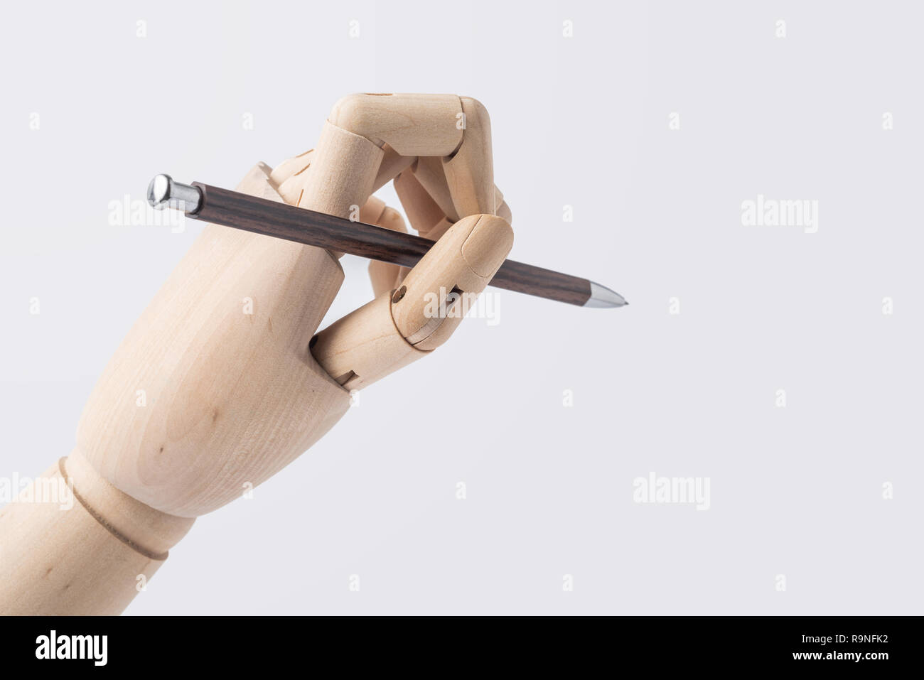 Business- und Designkonzept - hölzerne Hand halten Stift auf weißem Hintergrund Stockfoto