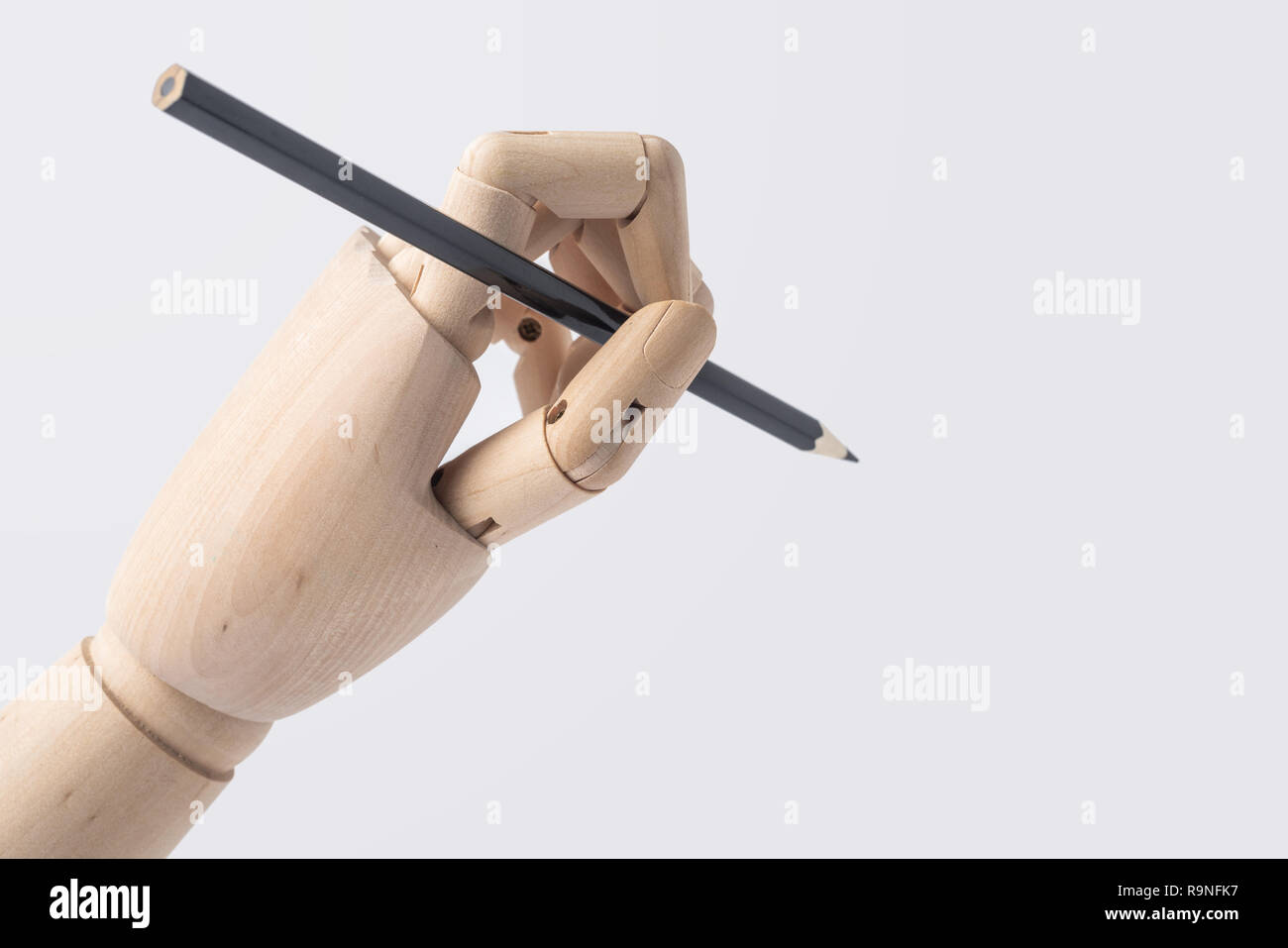 Business- und Designkonzept - hölzerne Hand halten Stift auf weißem Hintergrund Stockfoto