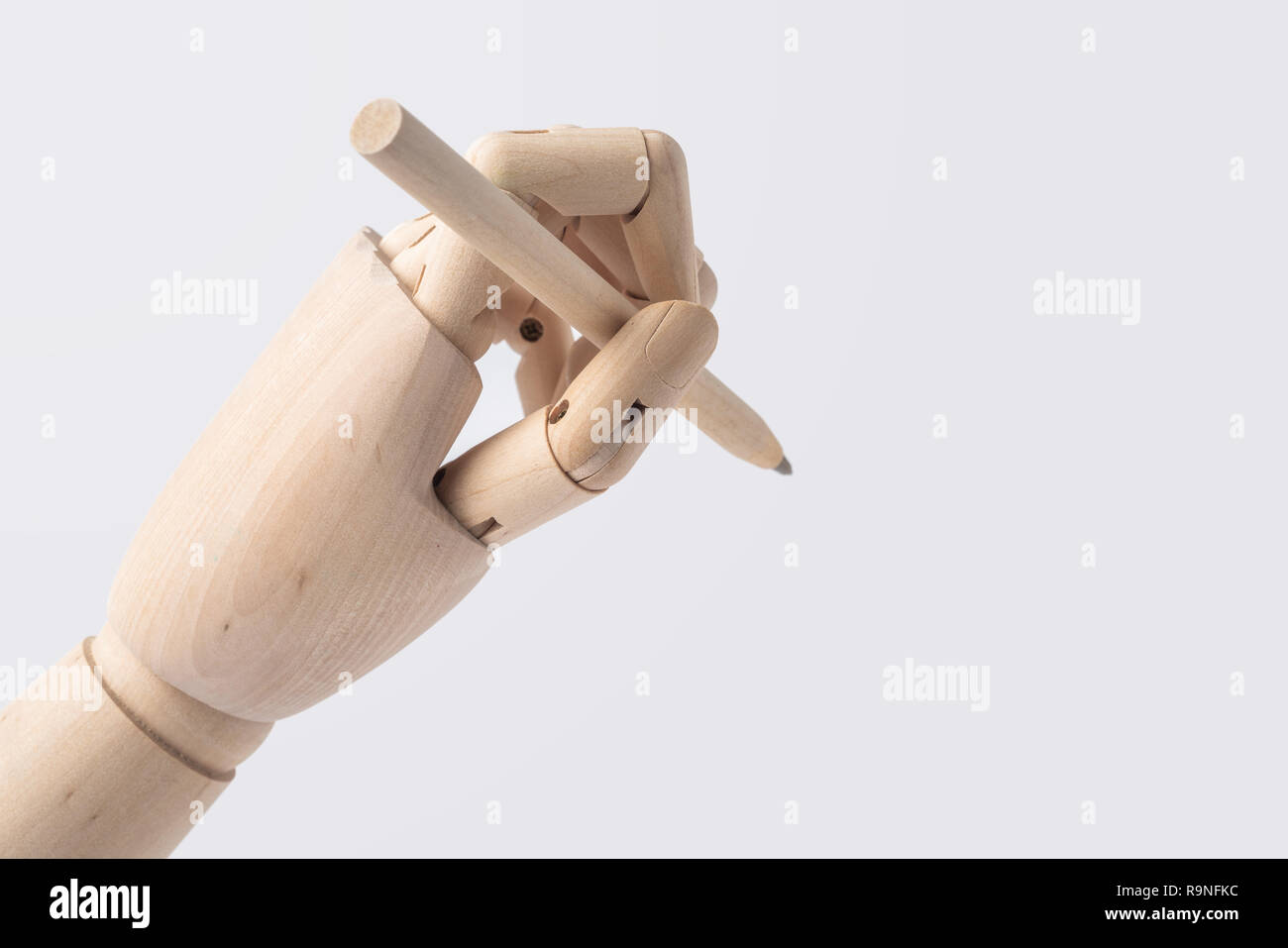 Business- und Designkonzept - hölzerne Hand halten Stift auf weißem Hintergrund Stockfoto