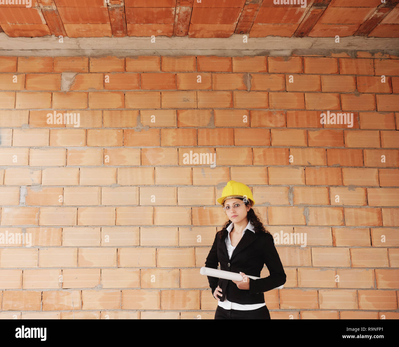 Frau im neuen Gehäuse. Portrait von Happy weiblichen Architekten holding Baupläne. Erwachsene Frau suchen und lächelnd an der Kamera mit Kopie Speicherplatz auf Stockfoto