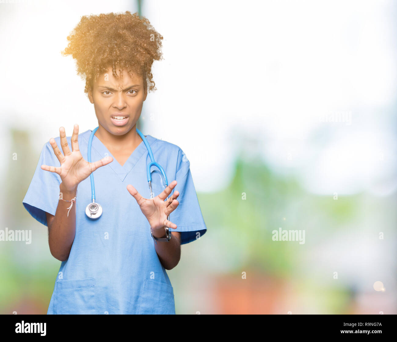 Junge afrikanische amerikanische Ärztin Frau über isolierte Hintergrund Angst und Furcht Ausdruck stop Geste mit den Händen entsetzt, geschockt zu schreien. Pan Stockfoto