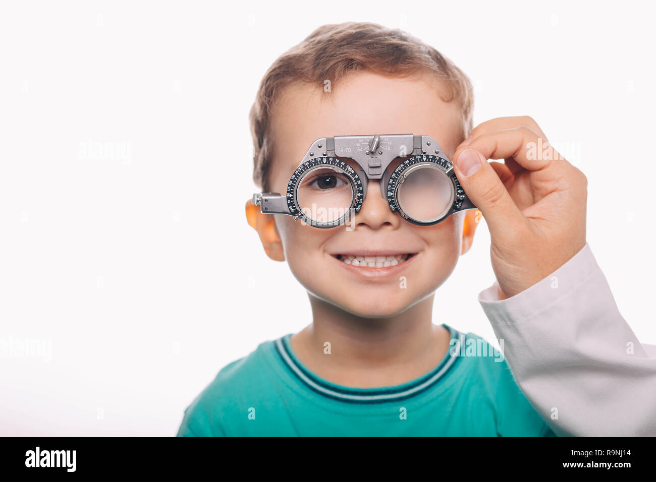 Optiker prüfen Vision von einem wenig freundlichen jungen mit Trial Rahmen Stockfoto