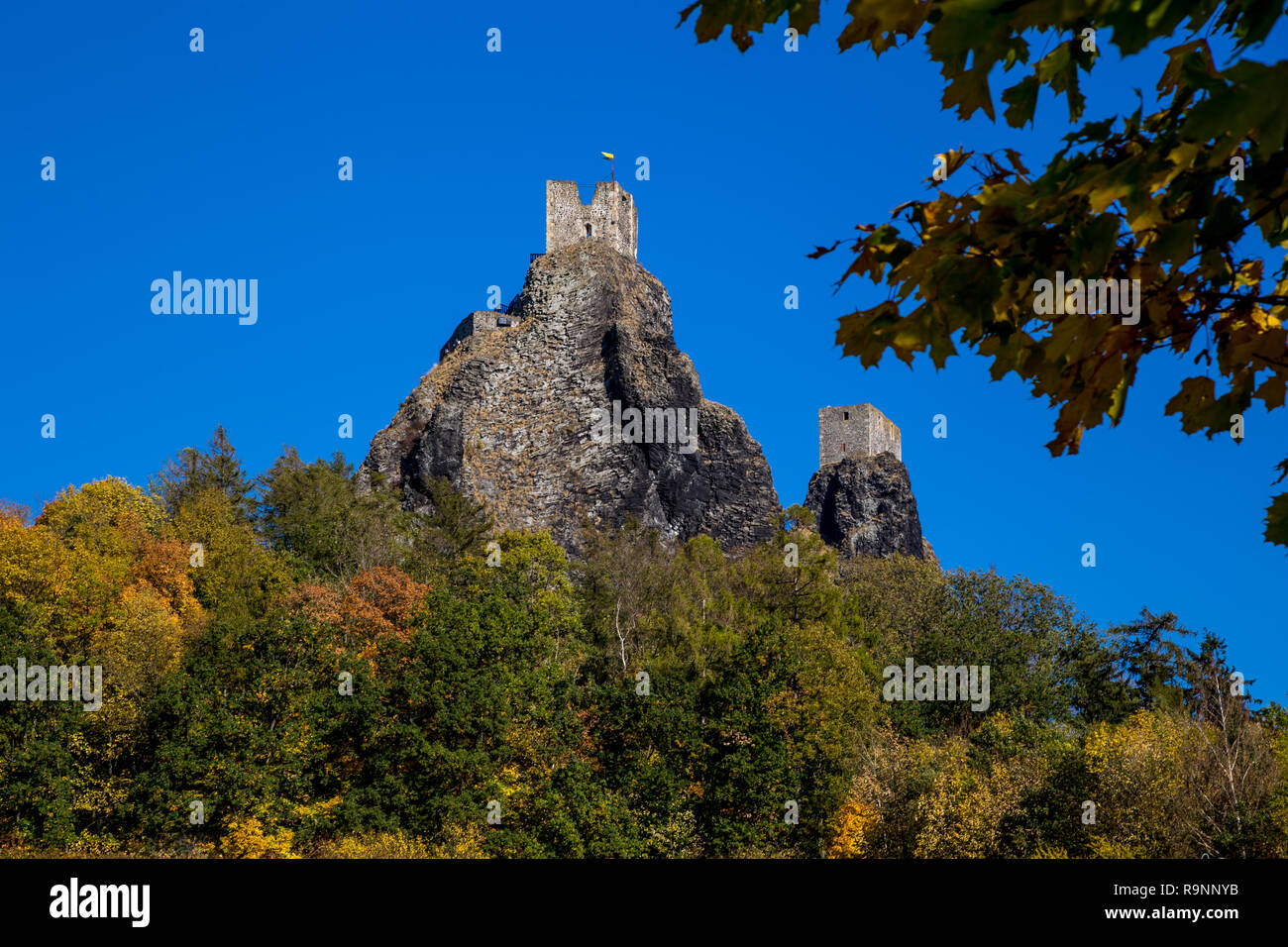 Herbst Landschaft in Böhmen dominierenden die Ruinen einer mittelalterlichen Burg auf einem Hügel und hohe Felsen. Historisches Wahrzeichen der Tschechischen Republik und eine beliebte Stockfoto