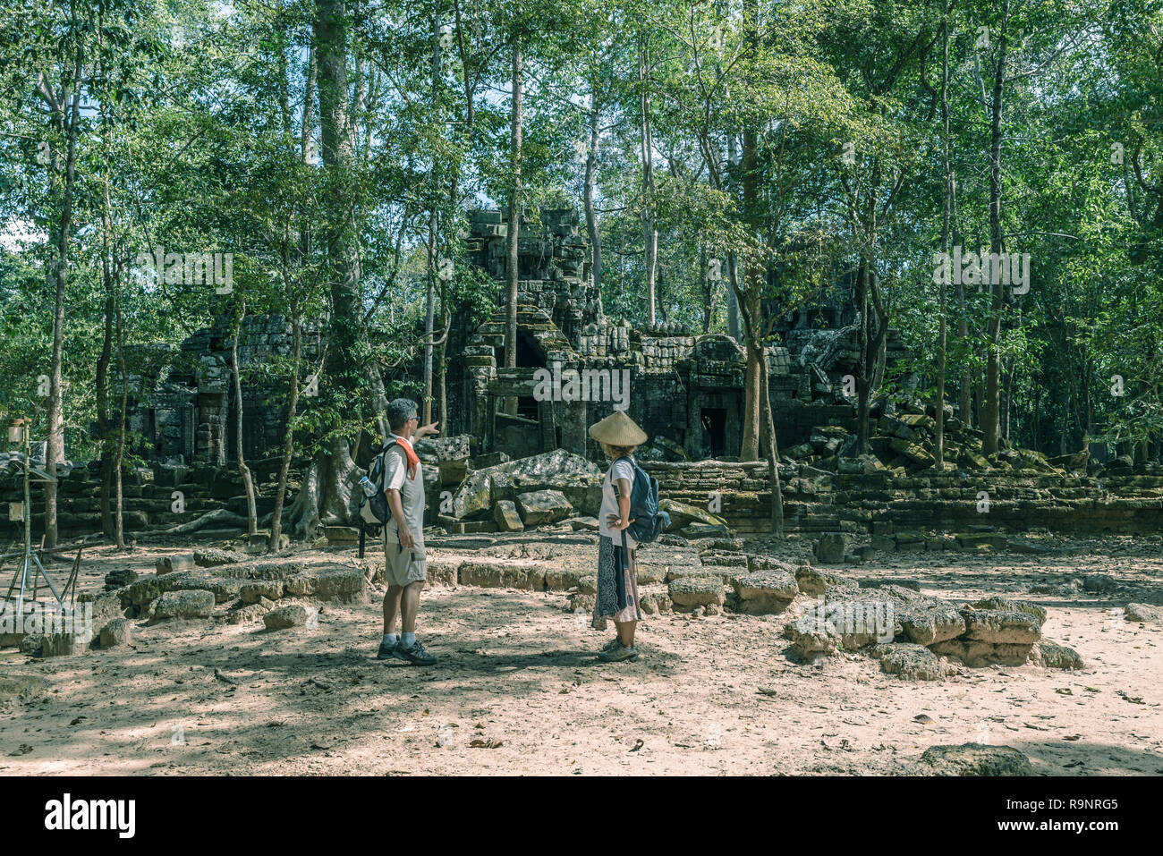 Touristische Paar besuchen Angkor Tempel, Kambodscha. Ta Nei Gebäude Ruinen im Dschungel. Umweltfreundliche Tourismus Reisen, getönten Bild. Stockfoto
