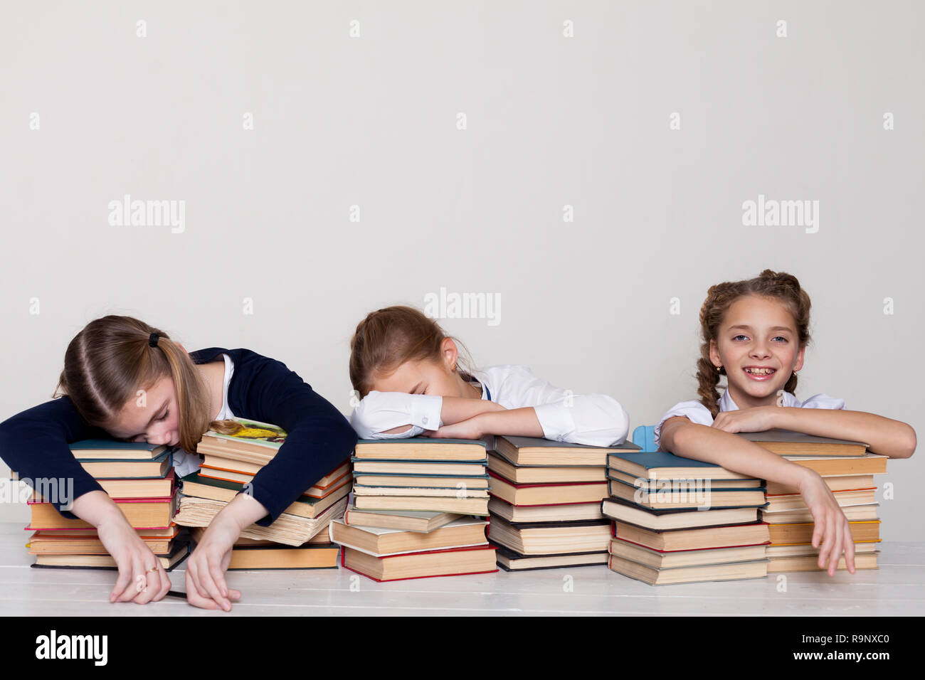 Drei Mädchen Schülerinnen an einem Schreibtisch mit Büchern über die Lektion in der Schule Stockfoto