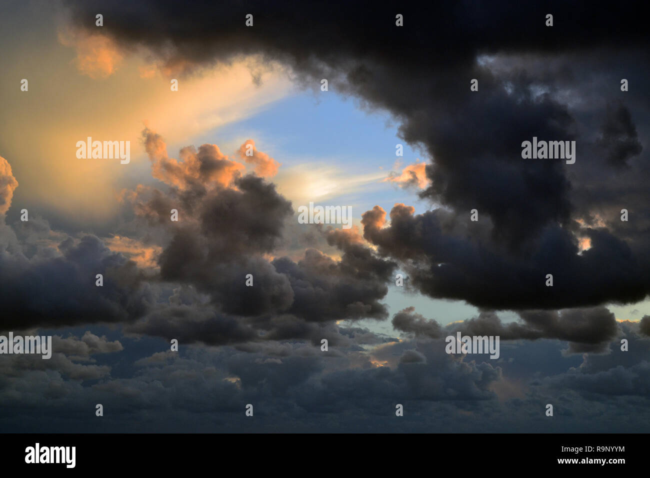 Stürmischen Himmel mit schwarzen und dunklen blauen Wolken und eine kleine blaue Pause unter ihnen Stockfoto