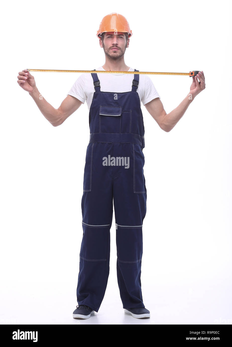 Im vollen Wachstum. Junge Builder mit gelbem Maßband. Stockfoto