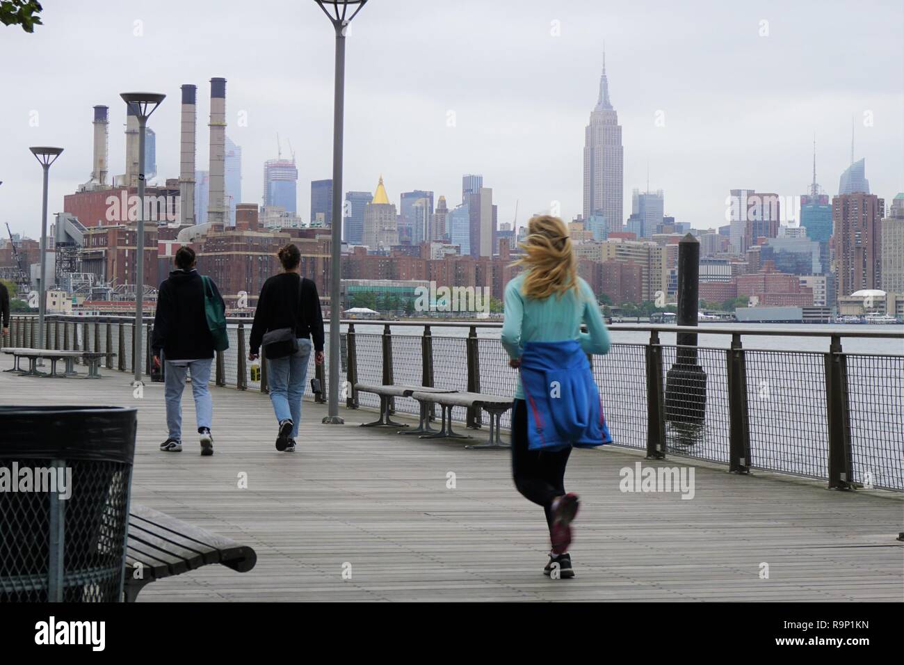 Jogger und Spaziergänger auf der Promenade in Brooklyn mit NYC Skyline im Hintergrund Stockfoto