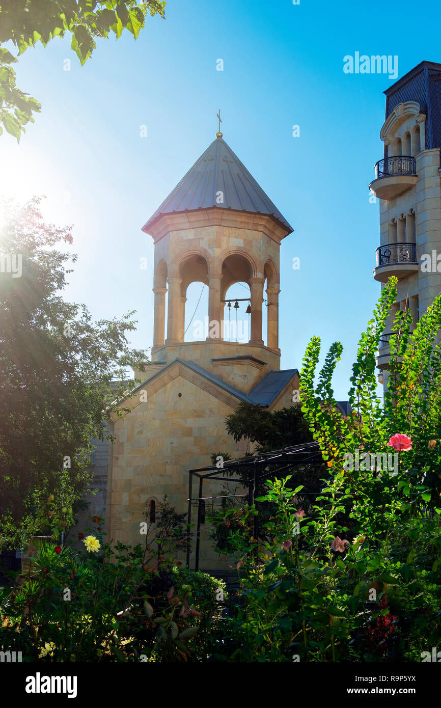 Alten Kirchturm der Kirche in Tiflis, Georgien und den schönen Garten. Strahlender Sonnenschein. Stockfoto