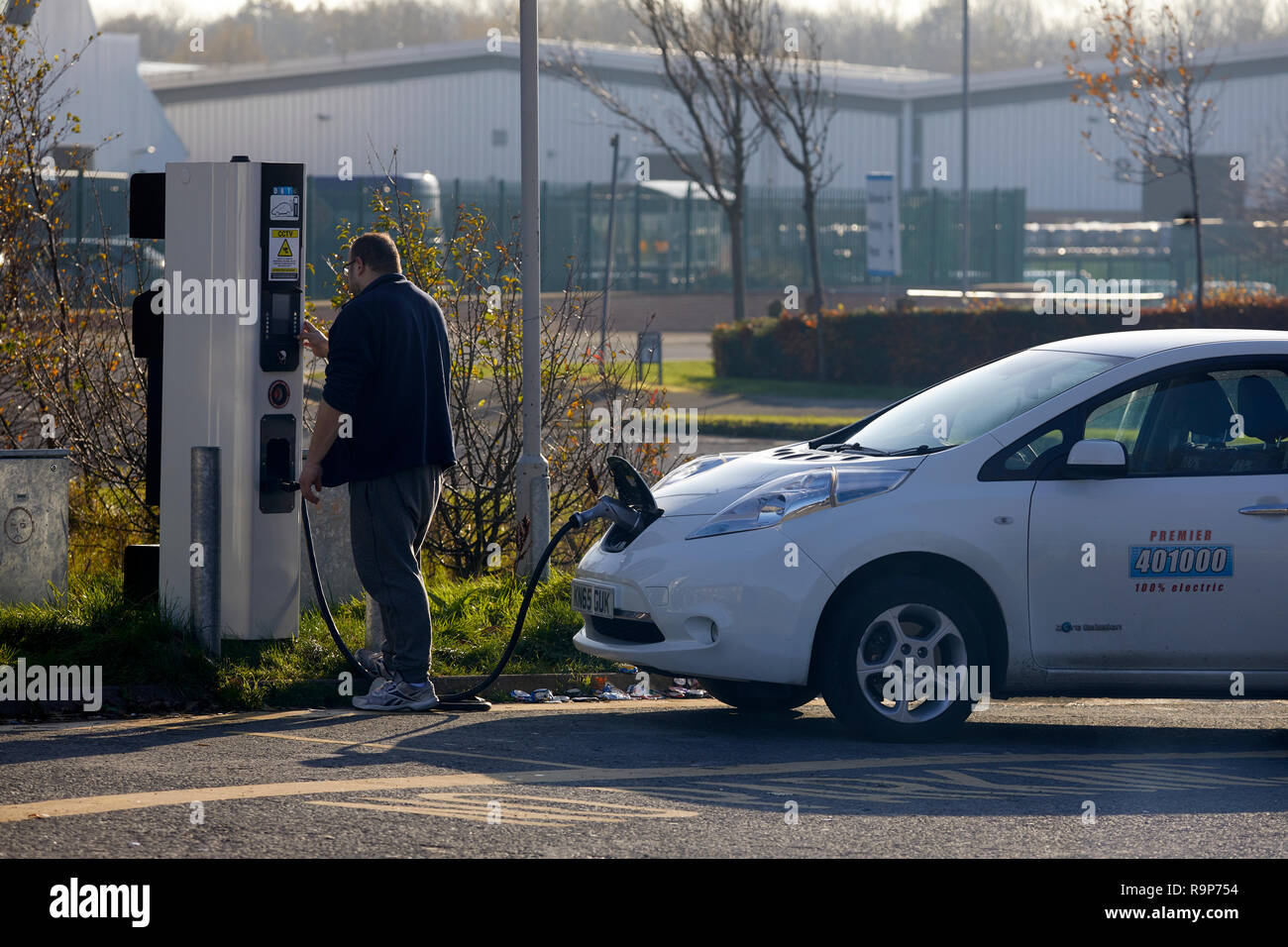 Blackpool, Lancashire Taxifahrer seine Nissan Leaf Auto aufladen an eine Ladestation Stockfoto