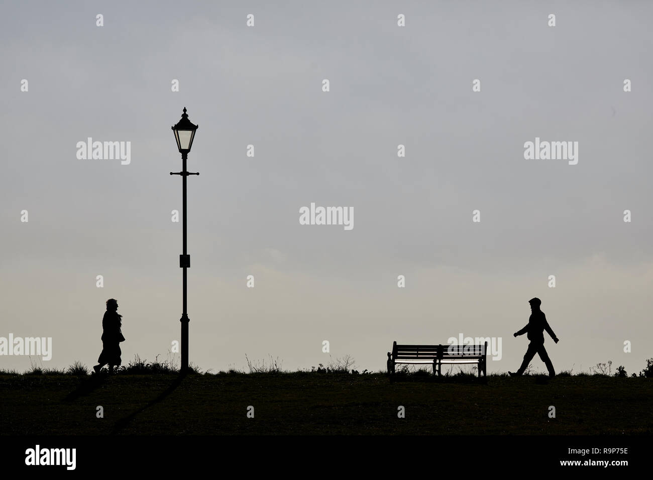 Lytham St. Annes Lancashire, direkt am Meer, Promenade Badeort an der irischen Küste von England, Silhouetten von Menschen zu Fuß entlang. Stockfoto