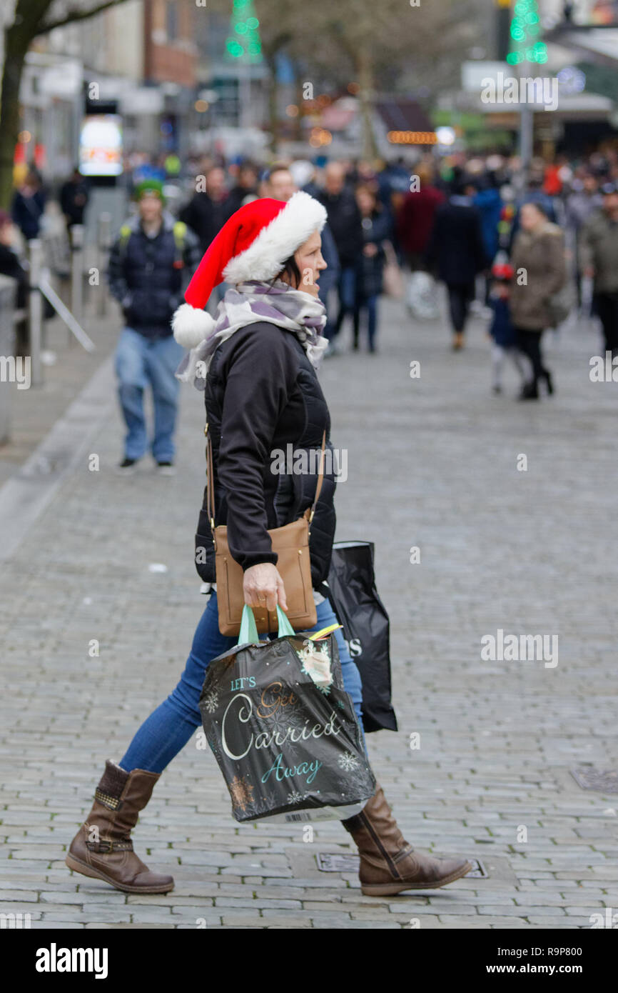 Last Minute Weihnachten Shopper mit einer Santa Hut in der Oxford Street, Swansea, Wales, UK. Montag, 24 Dezember 2018 Stockfoto