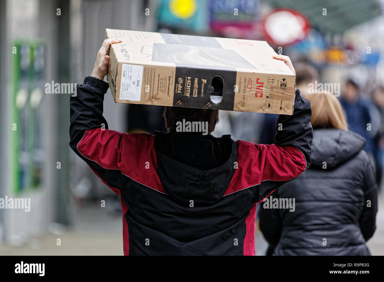 Last Minute Weihnachten shopper trägt einen Flachbild-TV in der Oxford Street, Swansea, Wales, UK. Montag, 24 Dezember 2018 Stockfoto