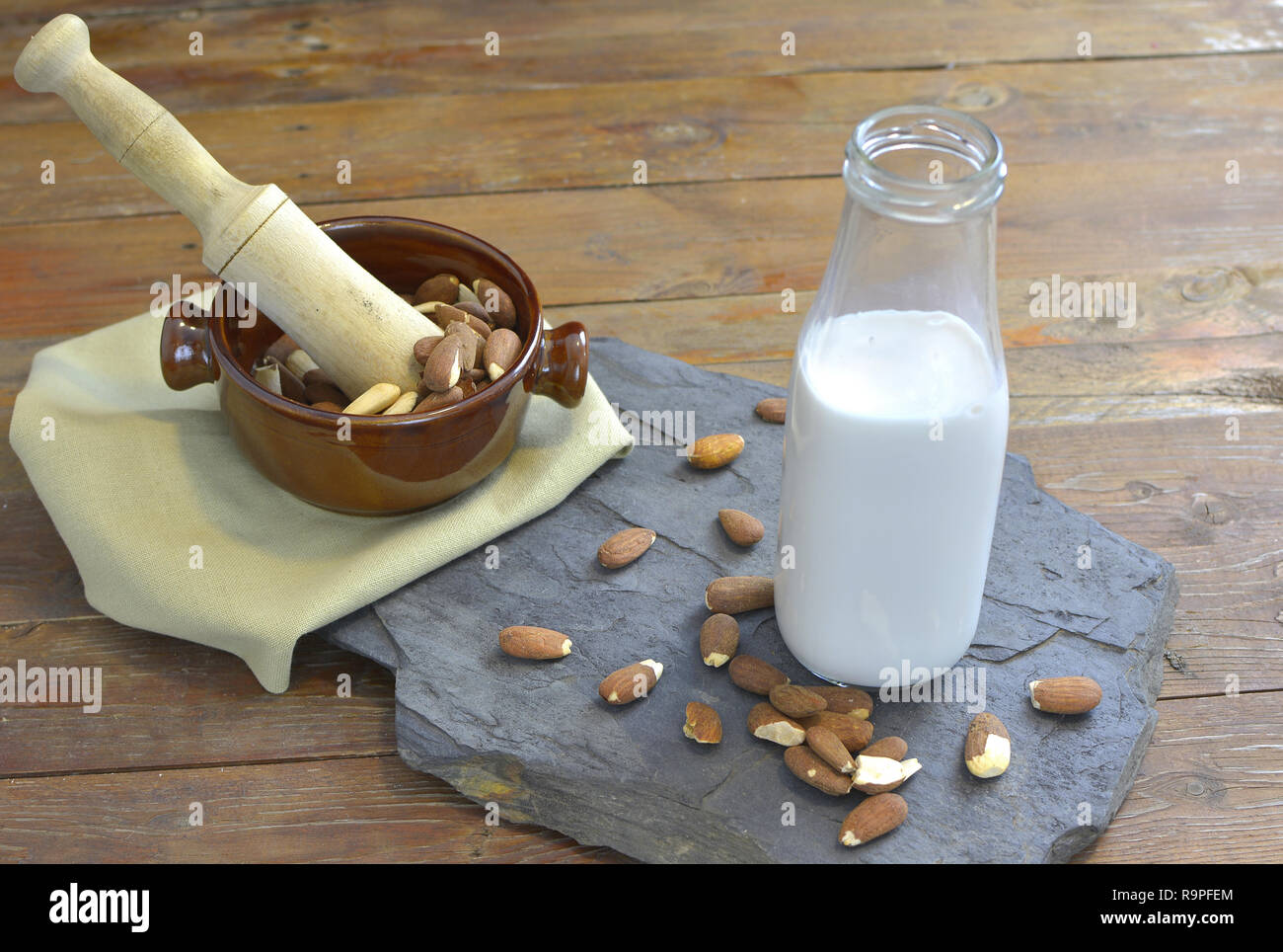 Hausgemachtes Mandel Milch in der Flasche mit Mandeln in eine Schüssel geben. Molkerei alternative Milch - close up mit Platz für Text Stockfoto
